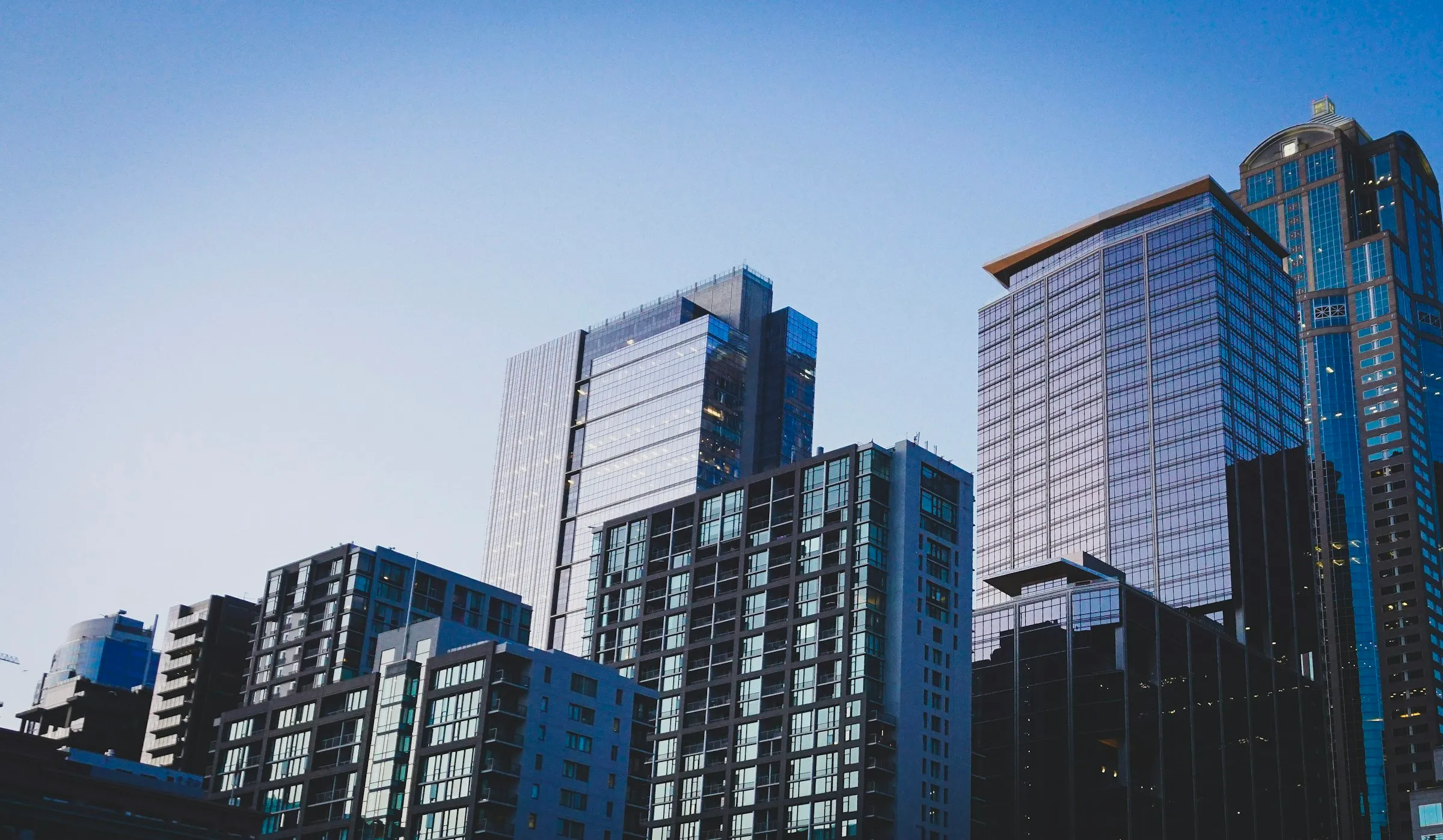 A cluster of modern high-rise residential and office towers photographed against a clear blue sky.
