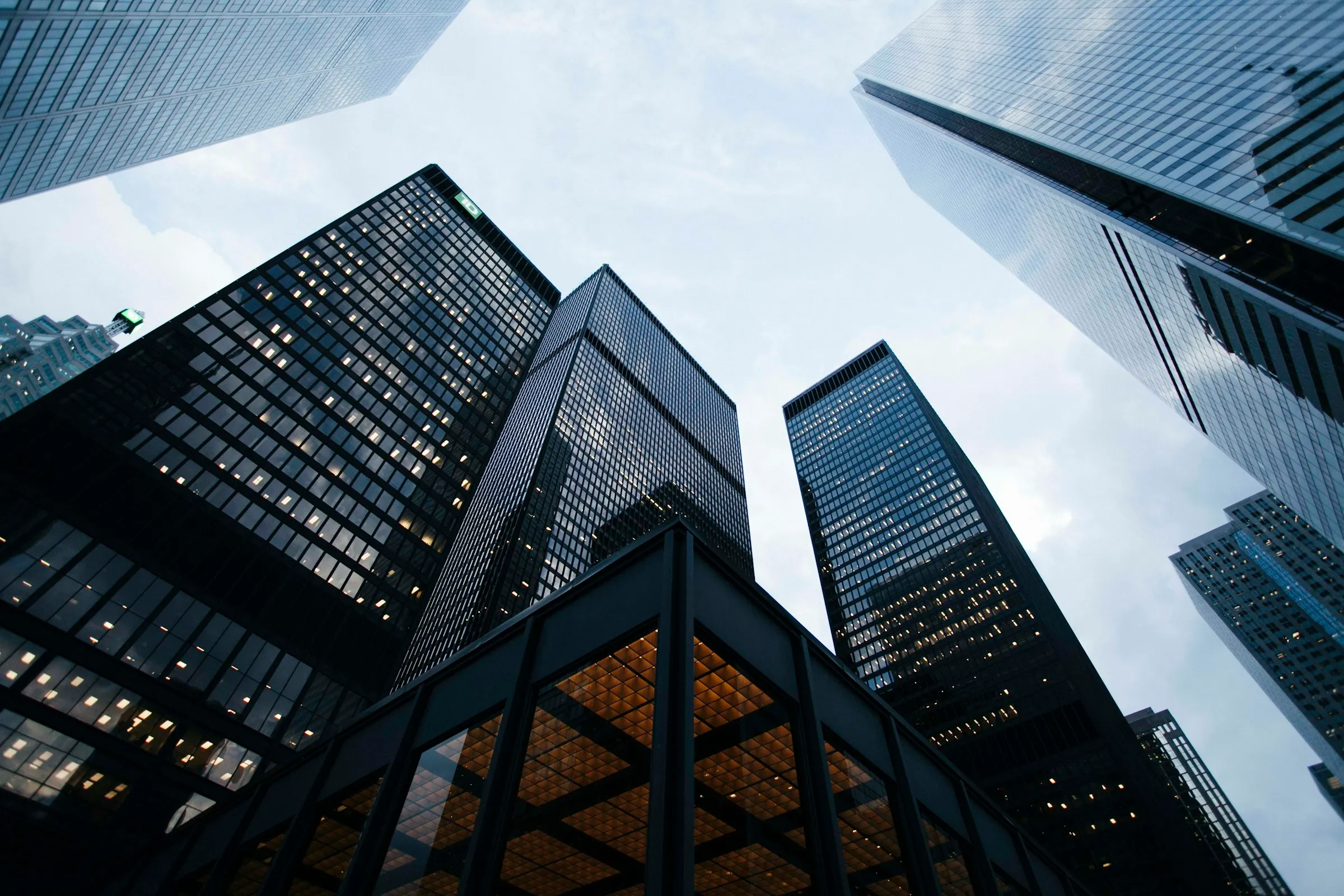Commercial office towers photographed looking upward from the base of a city block.